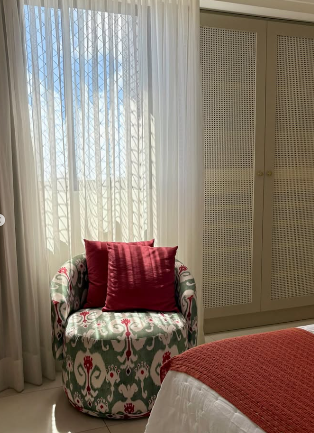 Poltrona estampada junto à janela e ao armário